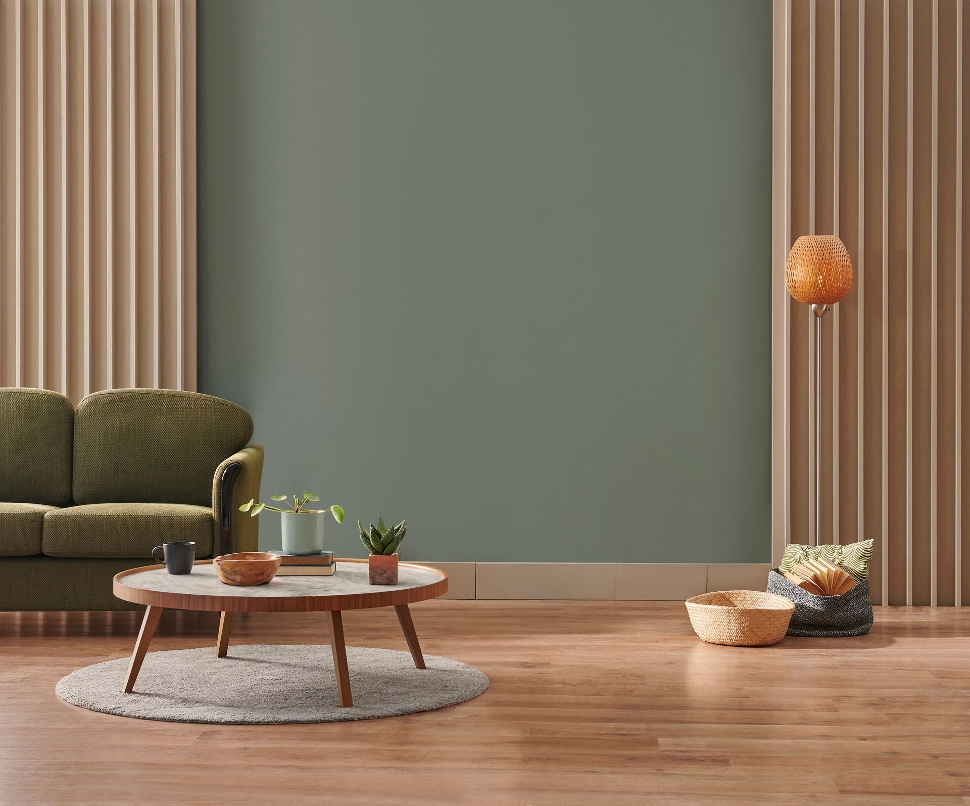 Salon moderne avec un mur vert sauge, des panneaux à lattes de bois, un canapé vert texturé et une table basse ronde.
