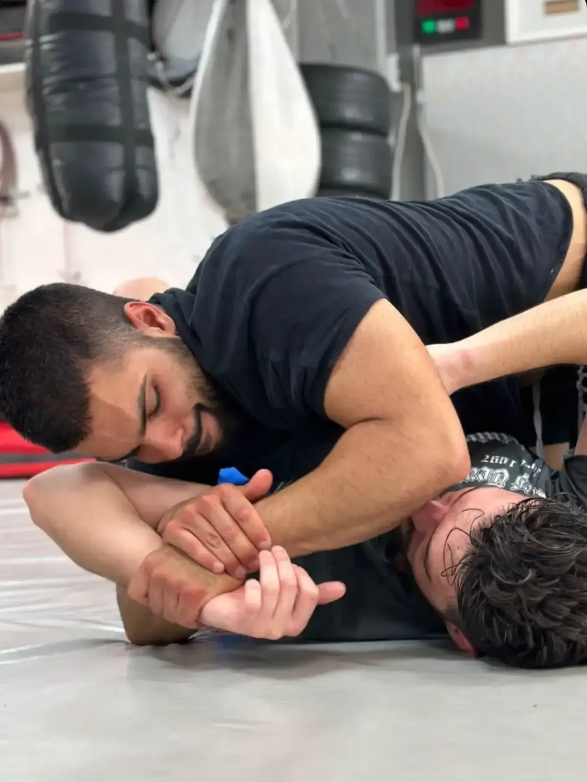 Dos atletas forcejeando sobre una colchoneta de gimnasio