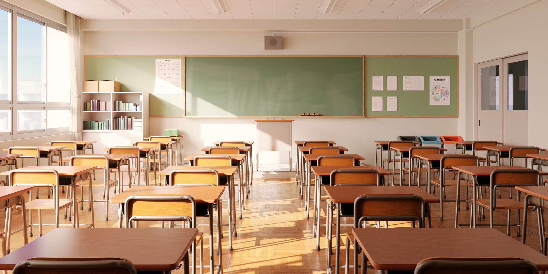 Une salle de classe vide, avec des rangées de pupitres face à un tableau noir.
