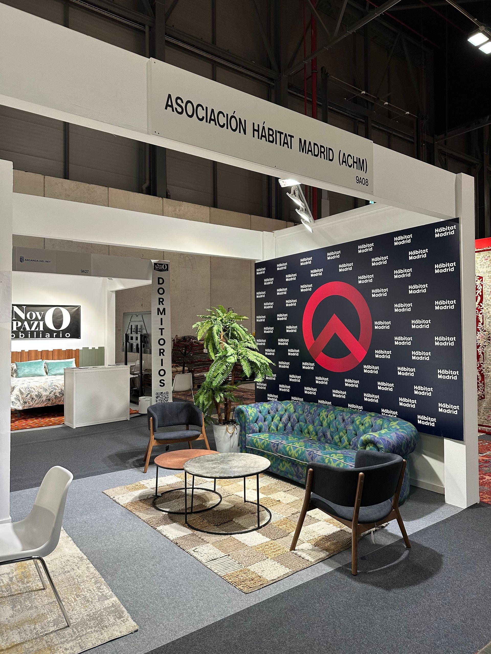 Sala de estar con un sofá marrón oscuro, grandes ventanales con persianas negras y una pared con acento de ladrillo.