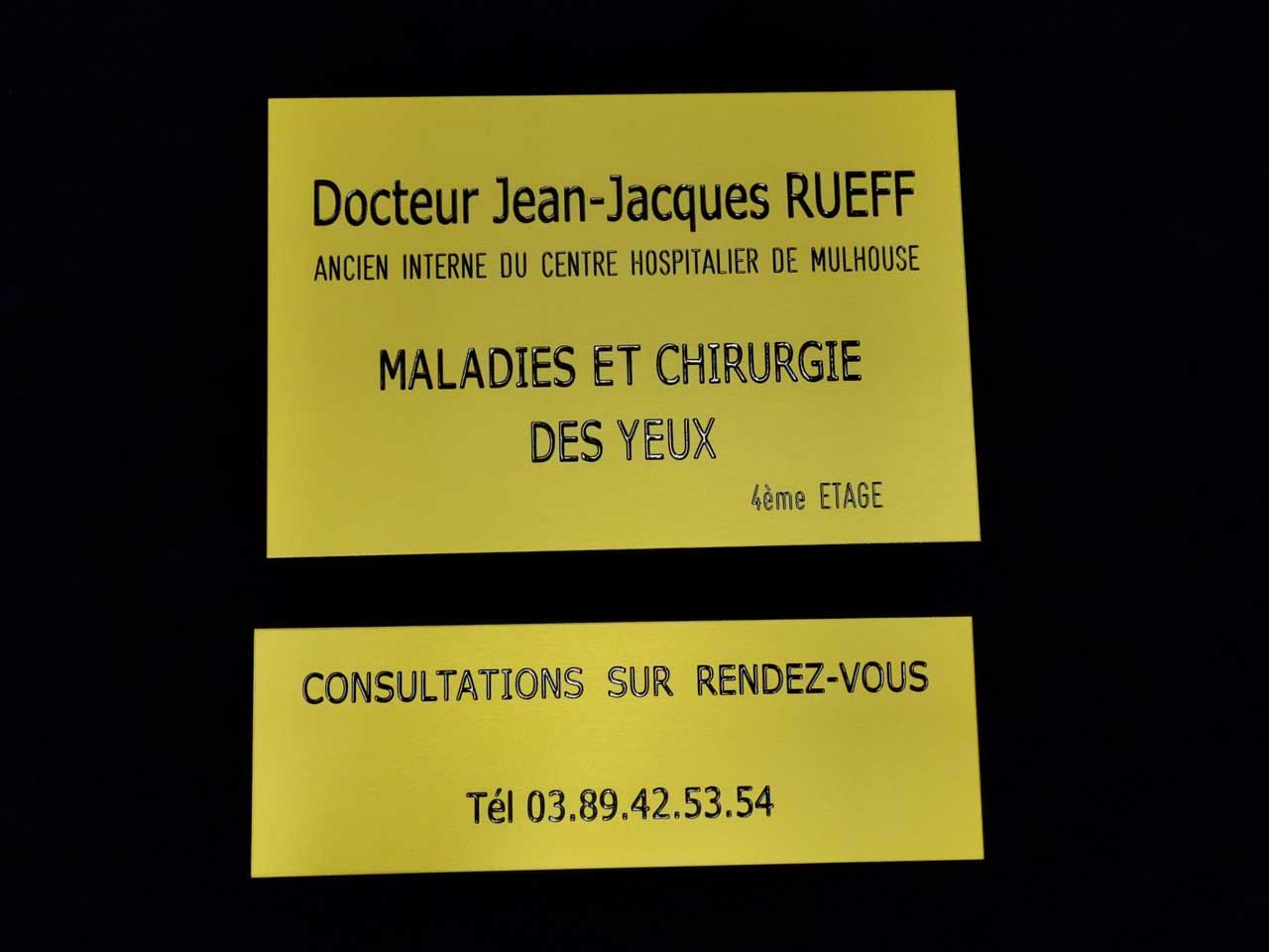 Carte de visite jaune avec texte pour un médecin ; elle mentionne le nom, la spécialité (maladies oculaires) et le numéro de téléphone.