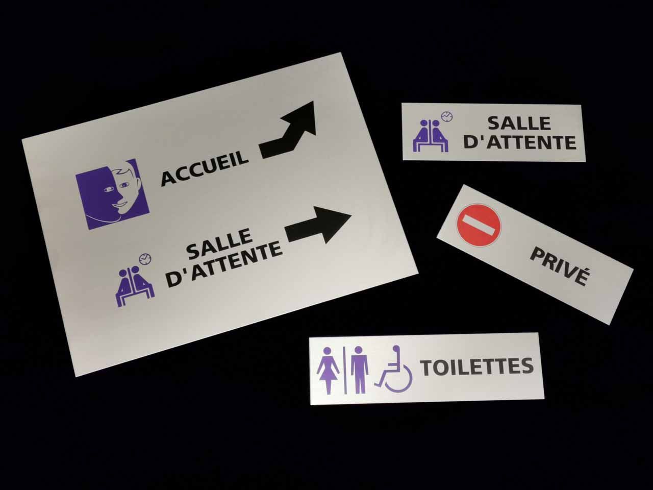 White directional signs with purple icons and text in French: accueil, salle d'attente, toilettes, privé.