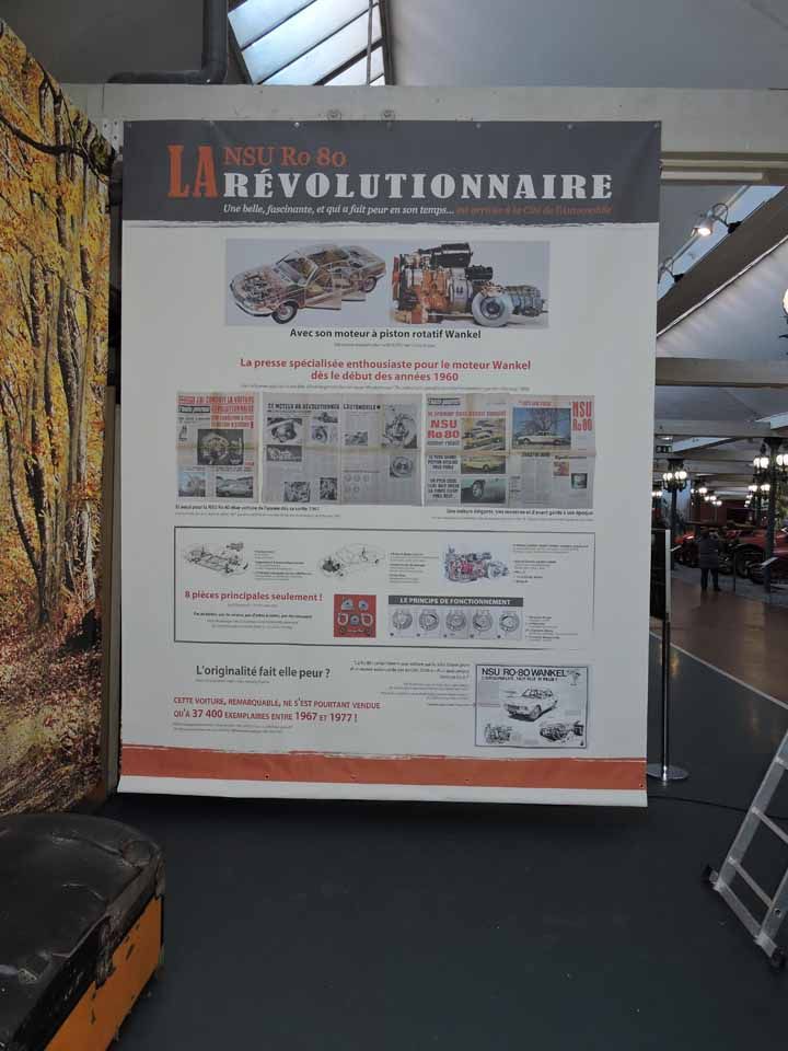 Affiche : « LA RÉVOLUTIONNAIRE » avec illustrations de voitures anciennes, coupures de presse et infographies.