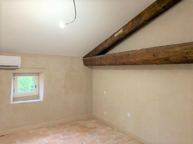 Mur avec application de lait de chaux et poutre apparente.