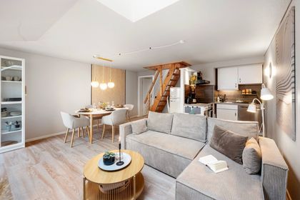 Wohnbereich mit Sofa und Blick zur Holztreppe, Ferienwohnung Mee(h)rblick