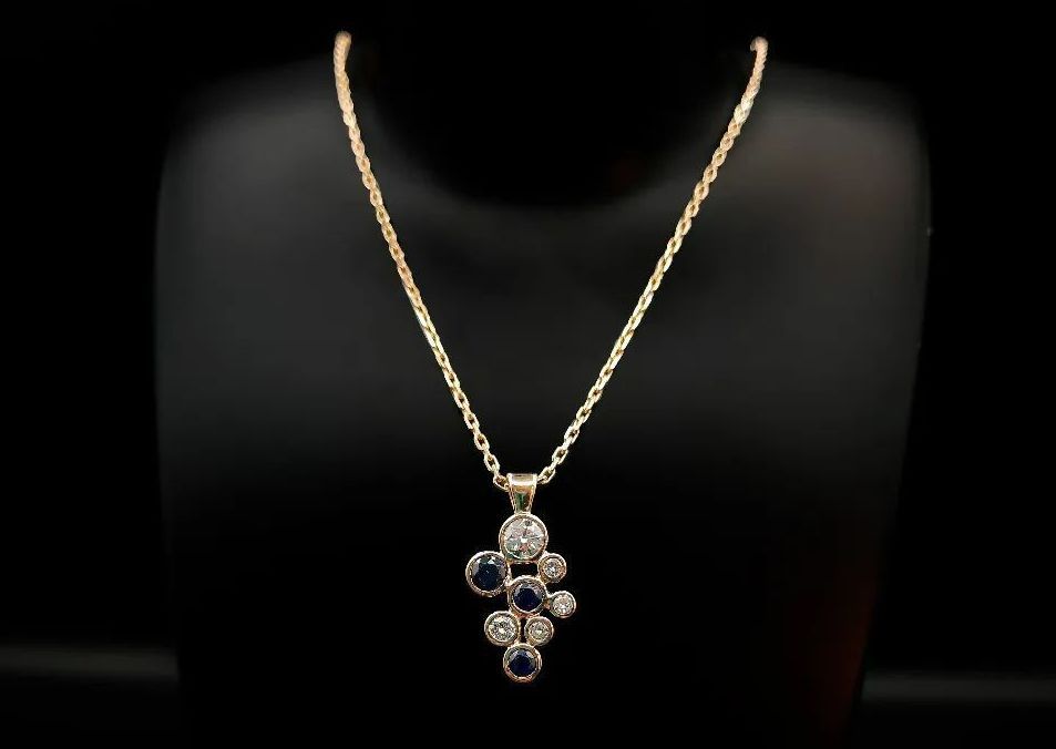 Un pendentif serti de 8 pierres posé sur un mannequin créé par l'Atelier du Beffroy