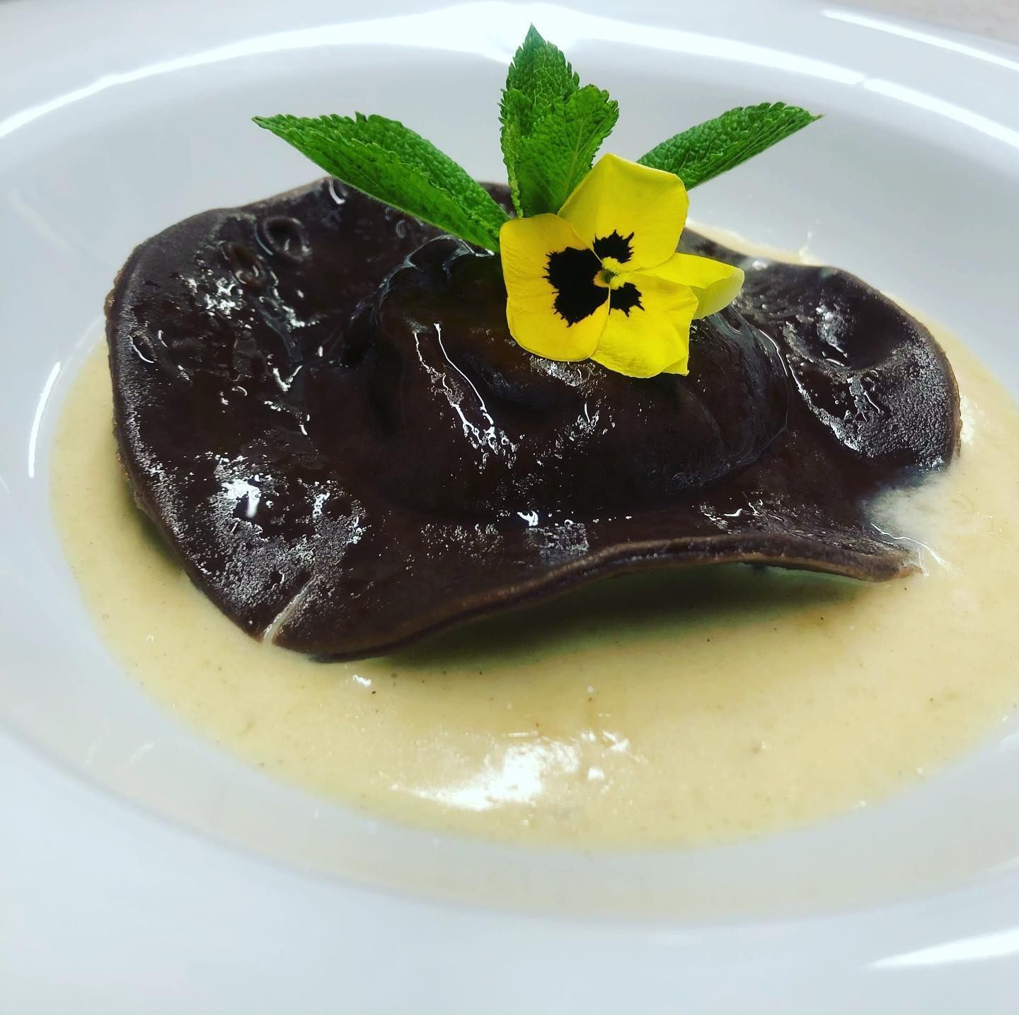 Raviolone al cacao, ripieno di ricotta di pecora e frutti canditi su crema alla cannella