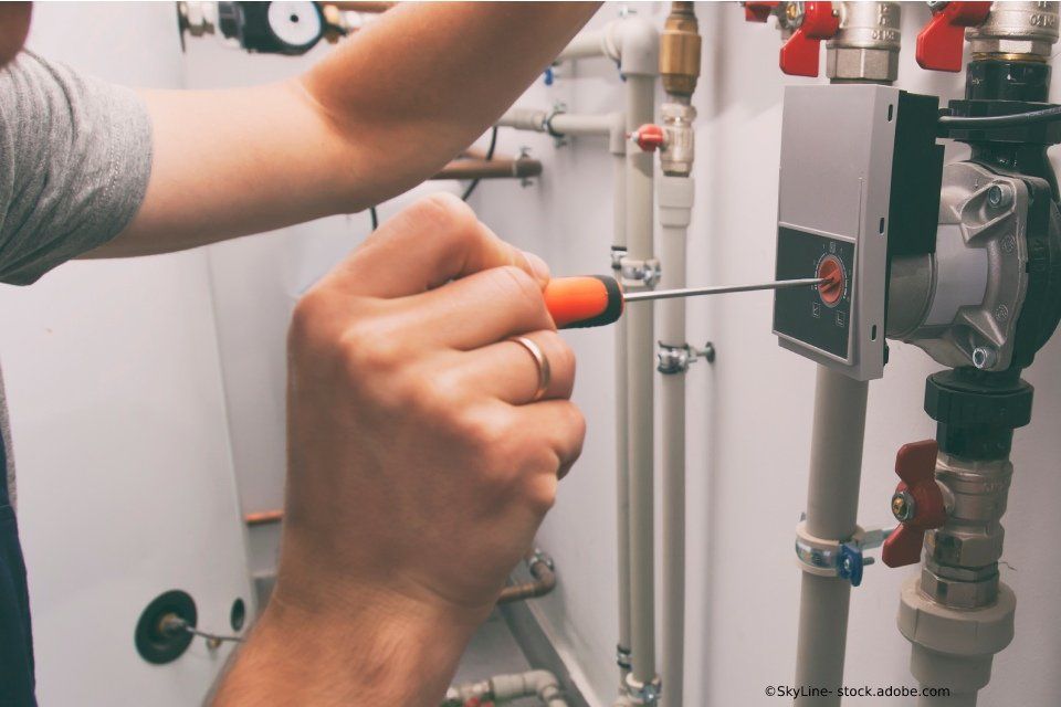 Mitarbeiter der Siwa Haustechnik GmbH installiert Heizung