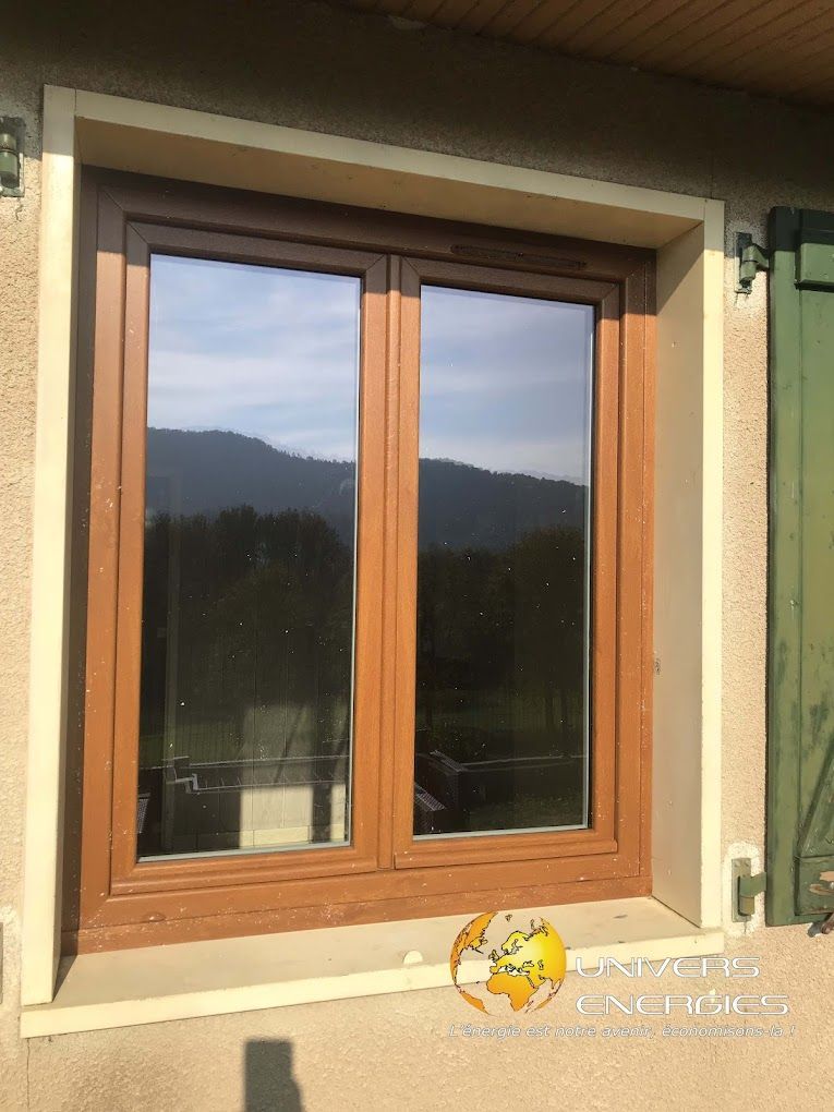 Une fenêtre en bois reflétant des montagnes