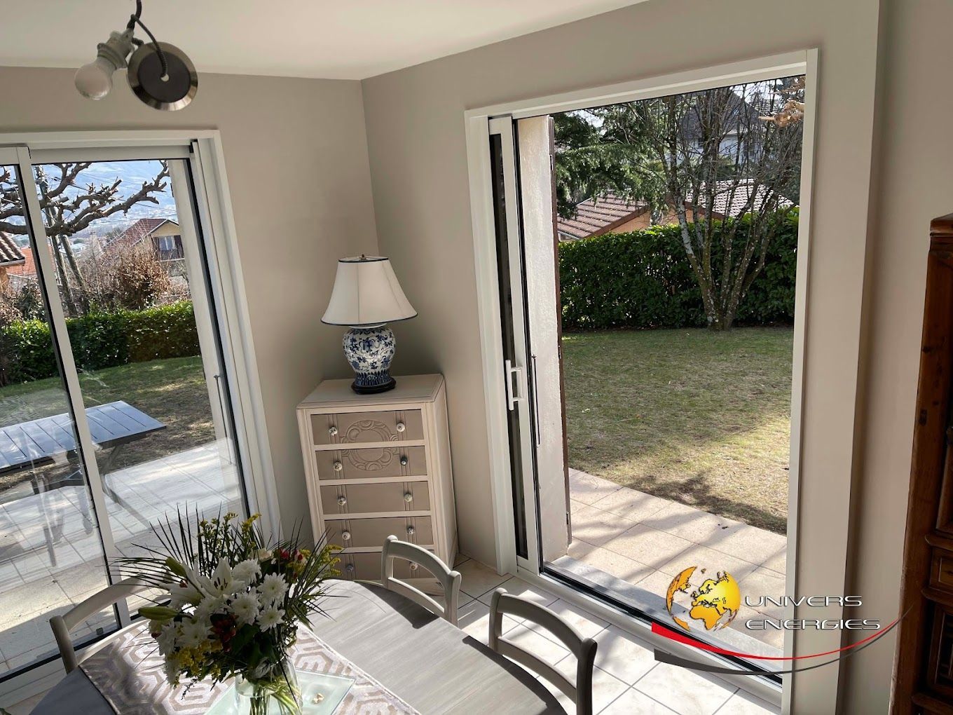 Un salon avec des baies vitrées ouvertes