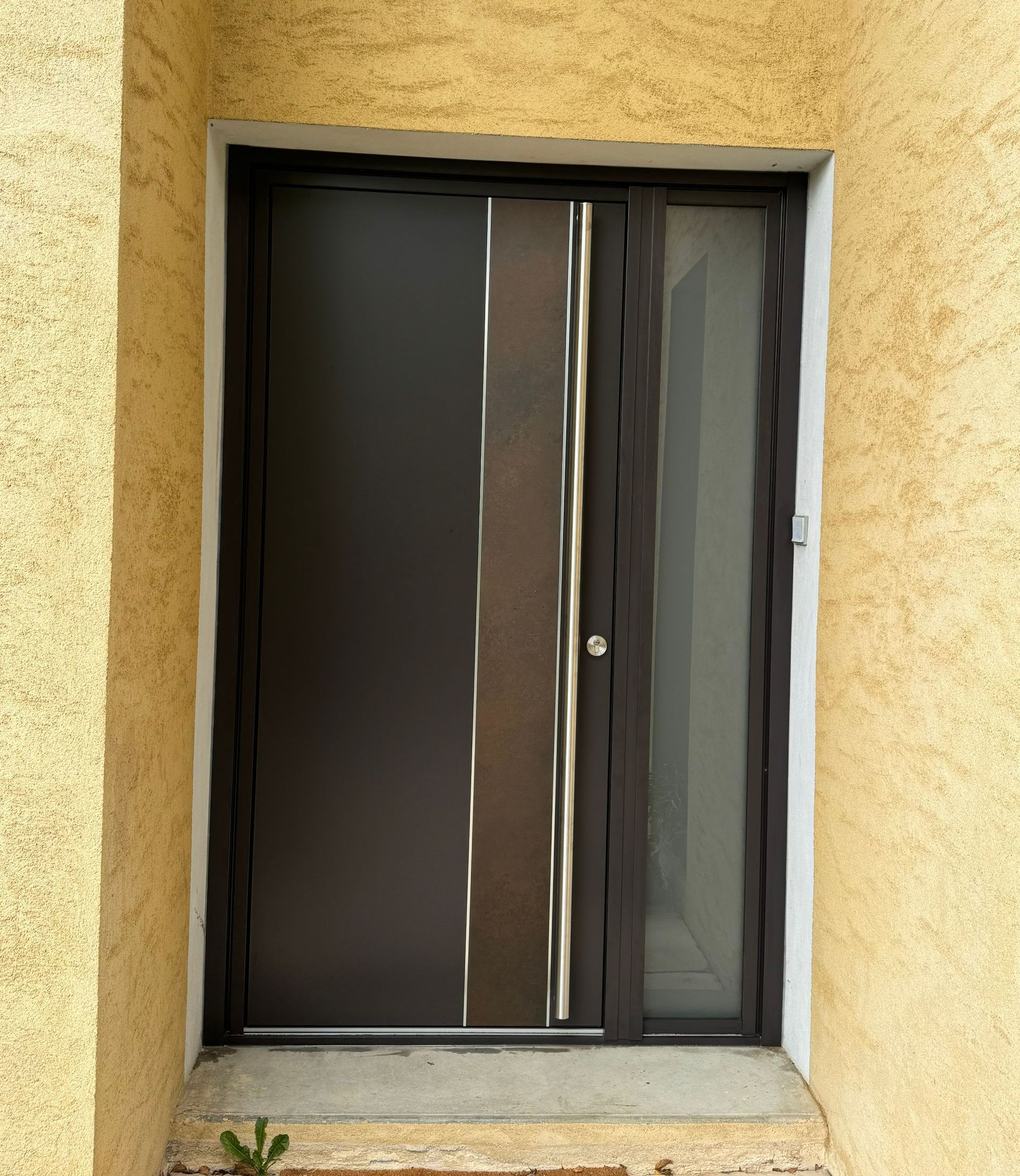 Une porte en aluminium avec une poignée verticale