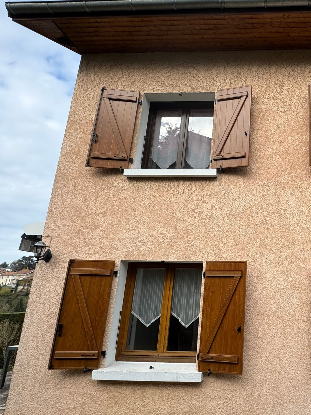 Des volets battants en bois, sur des fenêtres en bois