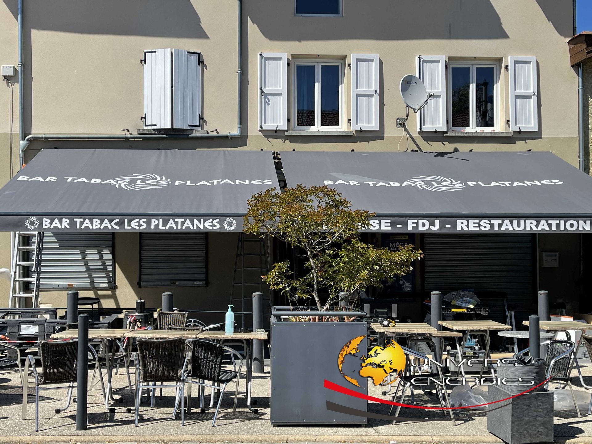 Un café « Bar Tabac Les Platangs » avec une terrasse extérieure sous un auvent gris.