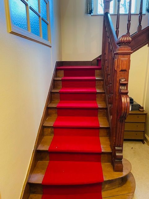 Moquette rouge sur un escalier en bois