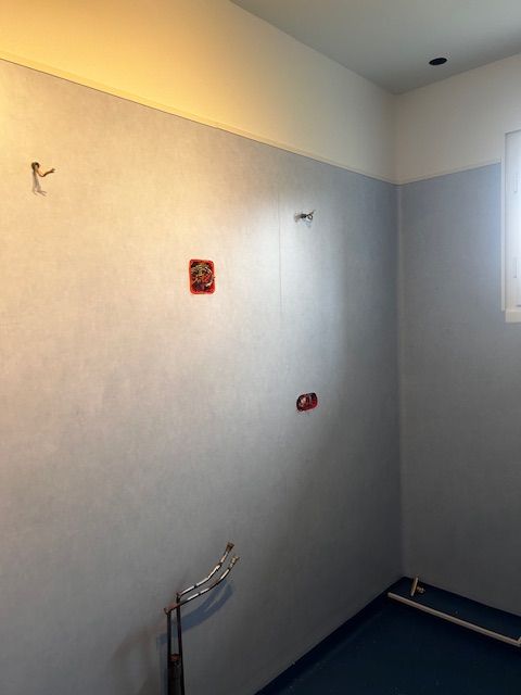 Mur peint en gris avec emplacements pour prises et arrivée d'eau