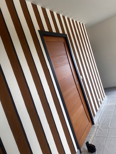 Mur tapissé avec un papier peint à rayures blanc et marron