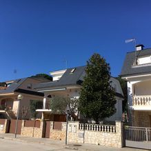 Una hilera de casas en un día soleado con un cielo azul en el fondo.