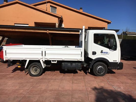 Un camión blanco está estacionado frente a una casa.