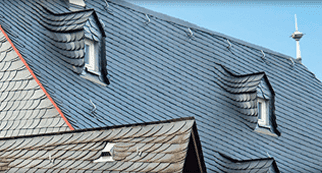 Un primer plano de un tejado con un cielo azul de fondo.