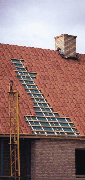 Un techo de tejas rojas con una chimenea encima.