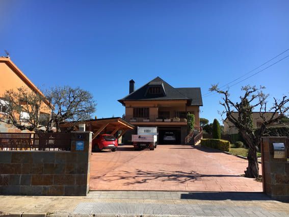 Una casa grande con un coche aparcado delante de ella.