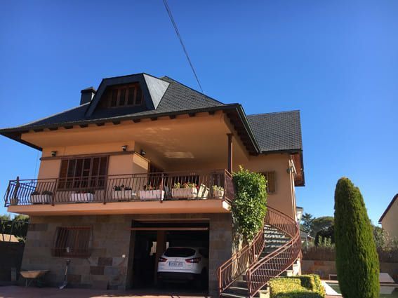 Una casa grande con un coche aparcado en el garaje