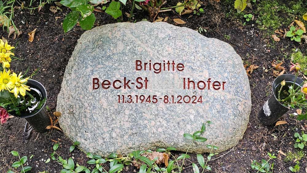 Auf dem Grabstein steht „Brigitte Beck-St. Ihofer 11.3.1945 - 8.1.2024“. Blumen säumen den Stein.