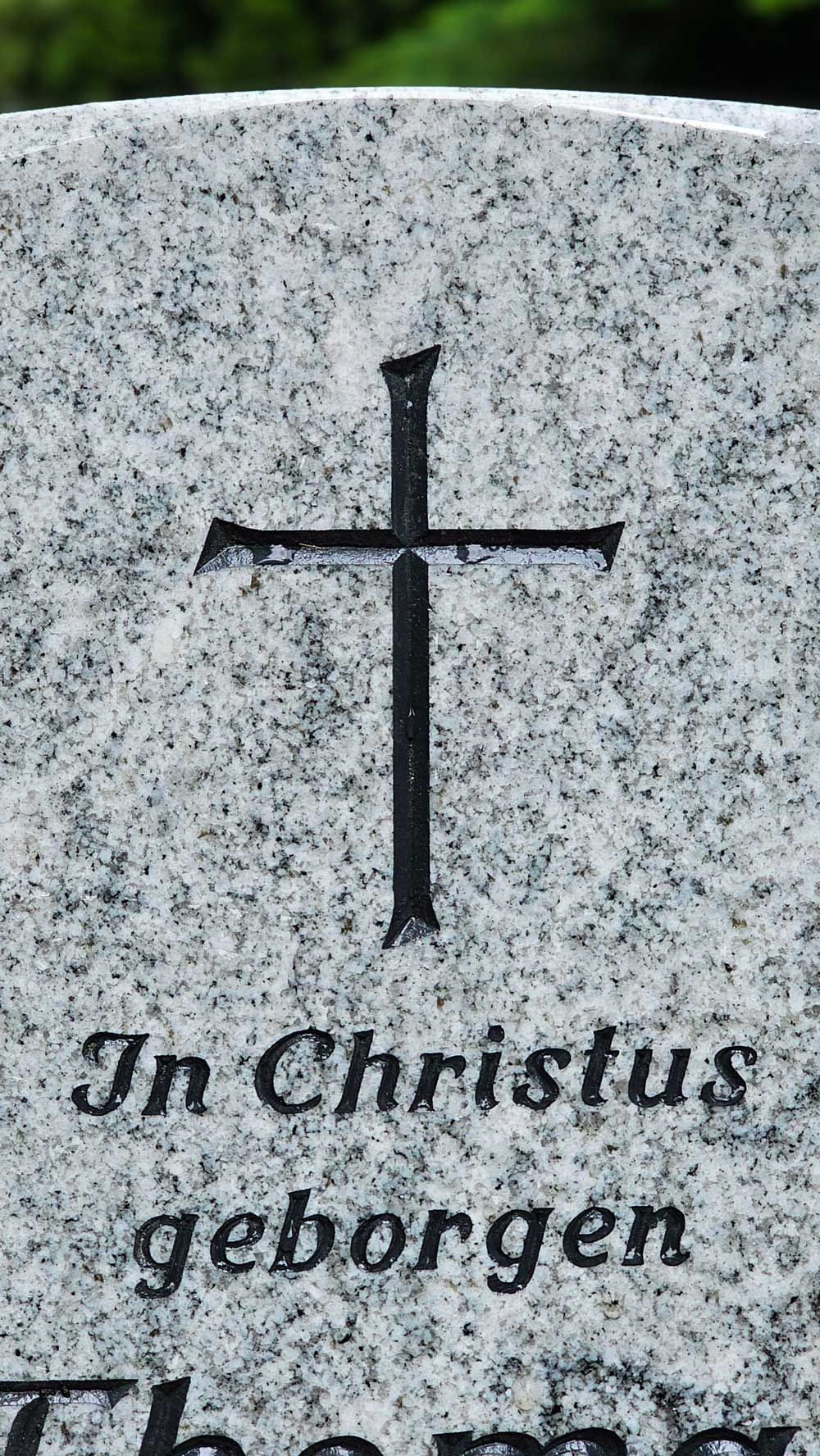 Grabstein mit einem Kreuz und der Inschrift „In Christus geborgen“.