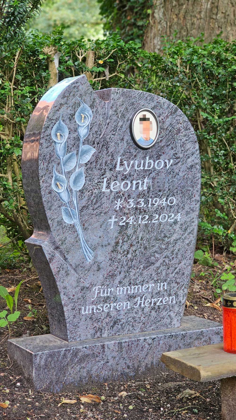 Granitgrabstein mit eingravierter Rose und Text, einschließlich eines Fotos.