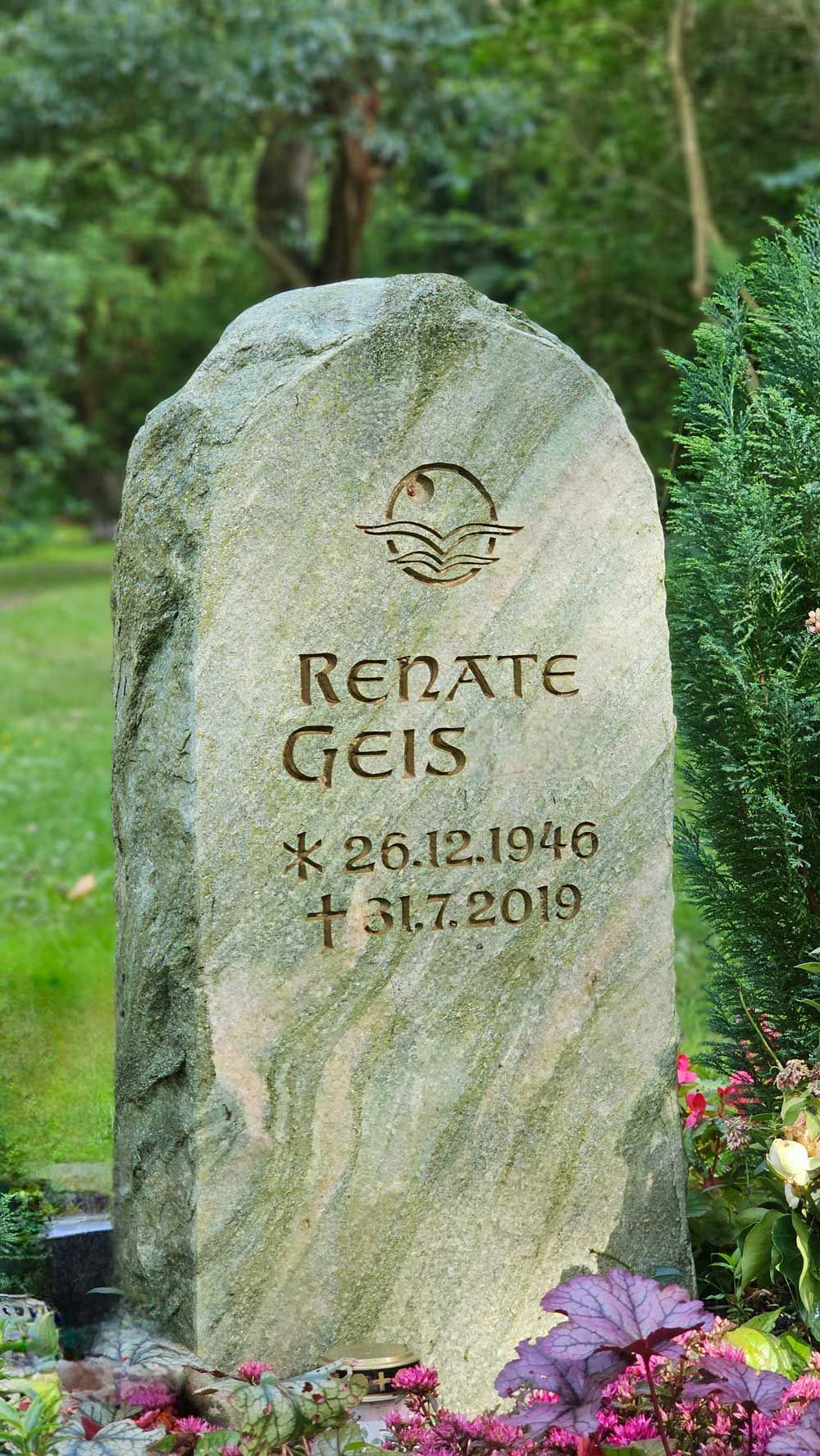 Grabstein mit der Inschrift „Renate Geis“, Geburts- und Sterbedatum sowie einem Globus-Symbol.