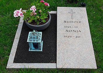 Grab mit Grabstein, Kreuz und den Namen Rudolf und Sonja, mit Topfpflanze und Laterne.