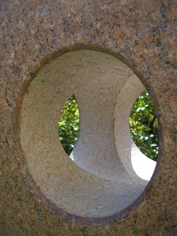 Nahaufnahme einer hellen Steinskulptur mit zwei kreisförmigen Öffnungen