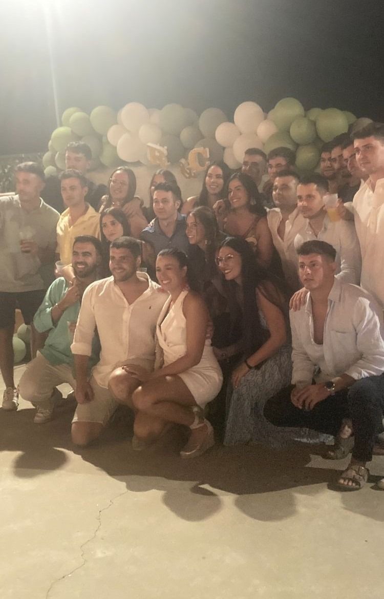 Un grupo de personas posa para una foto con globos de fondo.