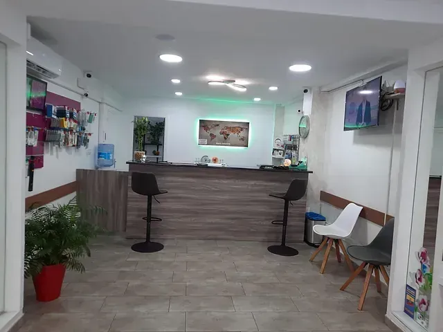 Una sala de espera con mostrador, sillas y televisión.
