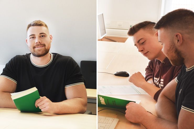 Zwei Männer sitzen an einem Tisch und lesen Bücher.