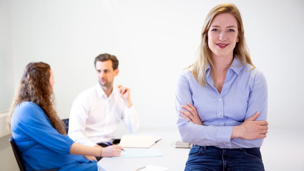 Eine Frau steht vor einer Gruppe von Menschen.