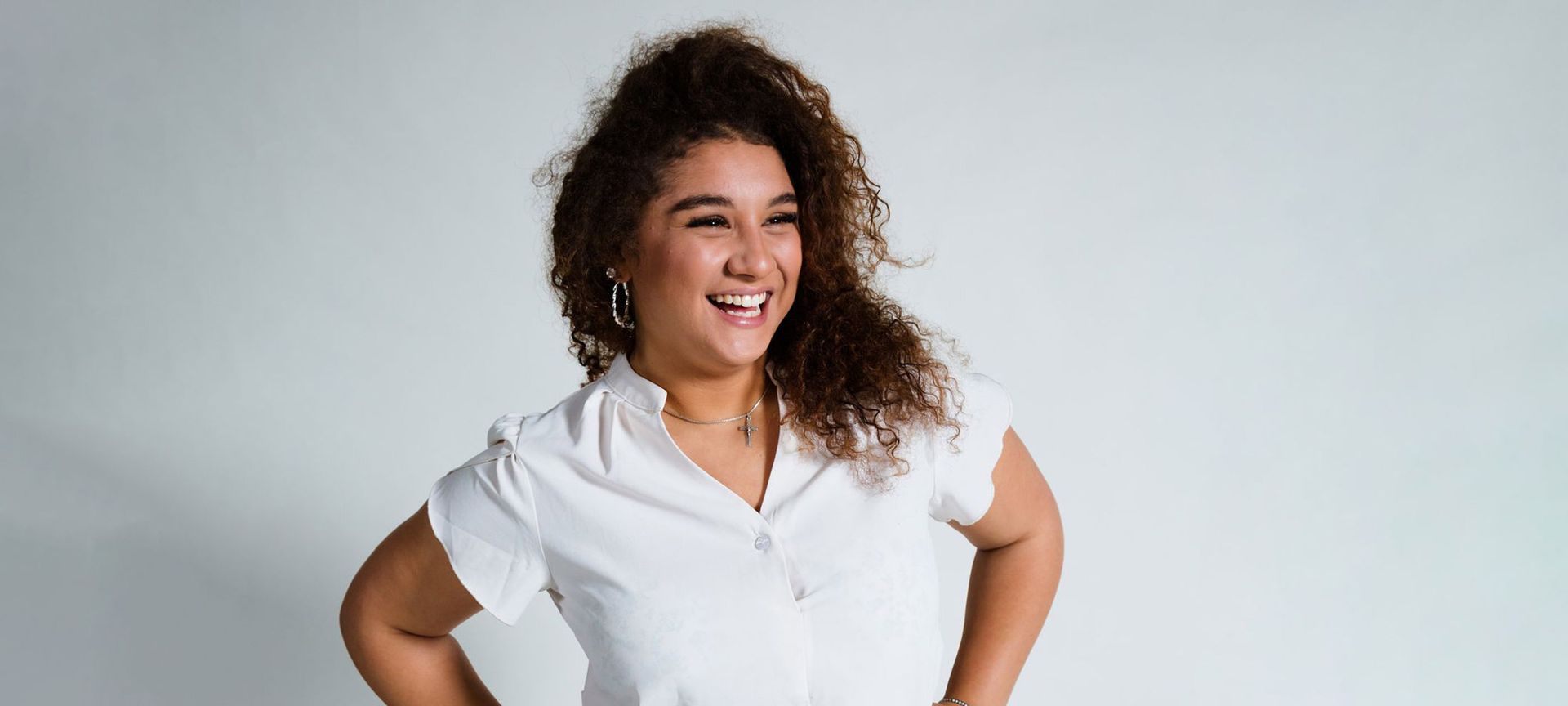 Ein junger Mann in einem gestreiften Hemd lächelt in die Kamera.