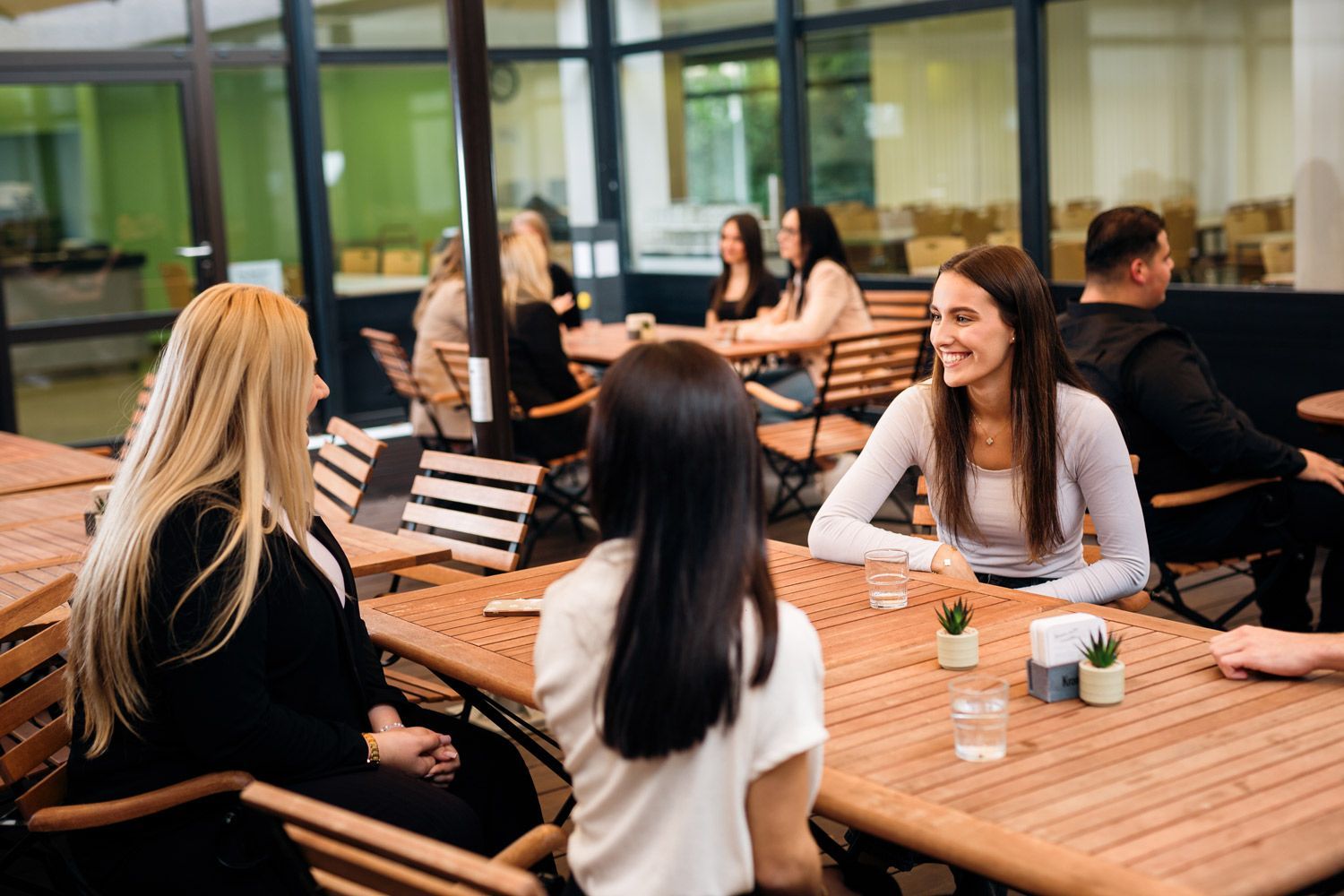 Eine Frau sitzt an einem Tisch und schreibt in ein Notizbuch.