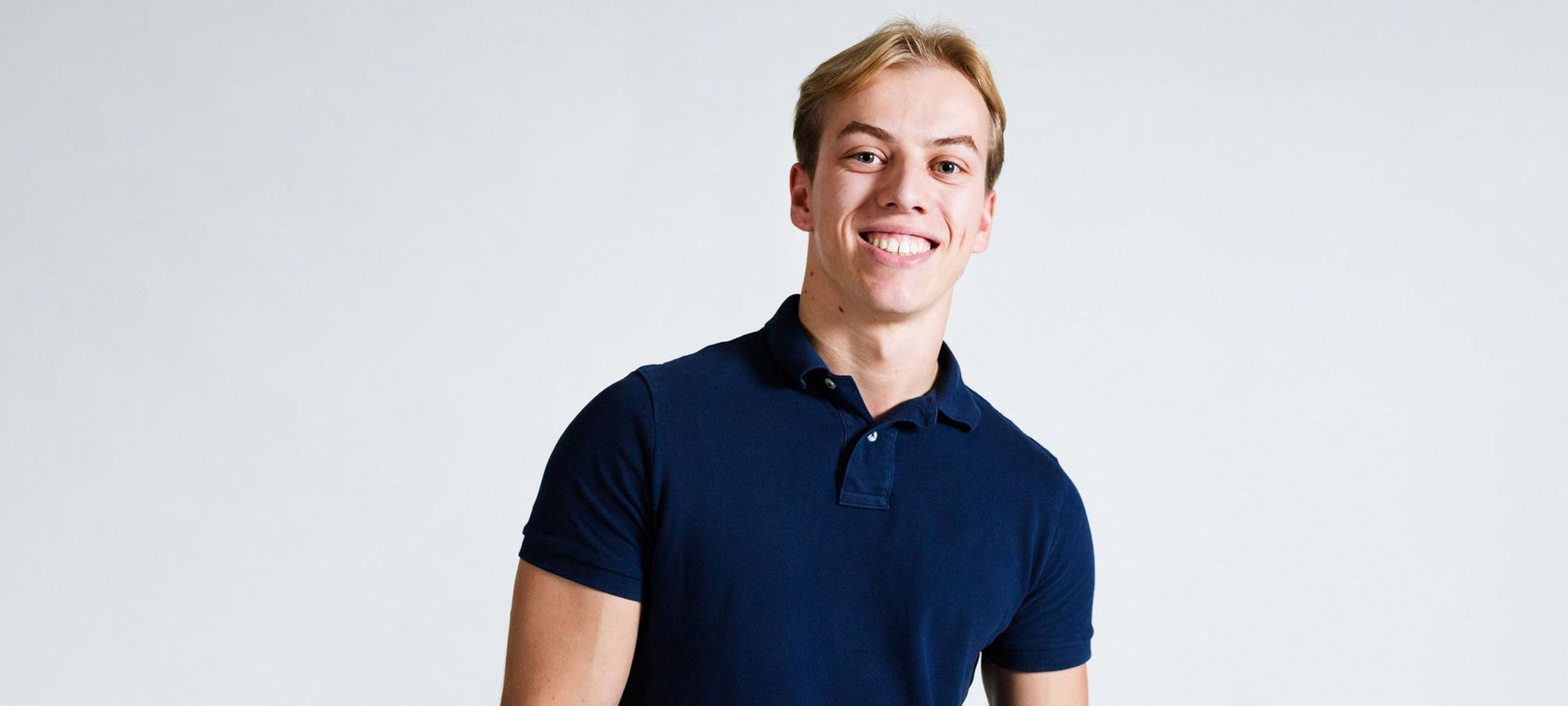 Eine Frau in einem hellbraunen Pullover lächelt und schaut in die Kamera