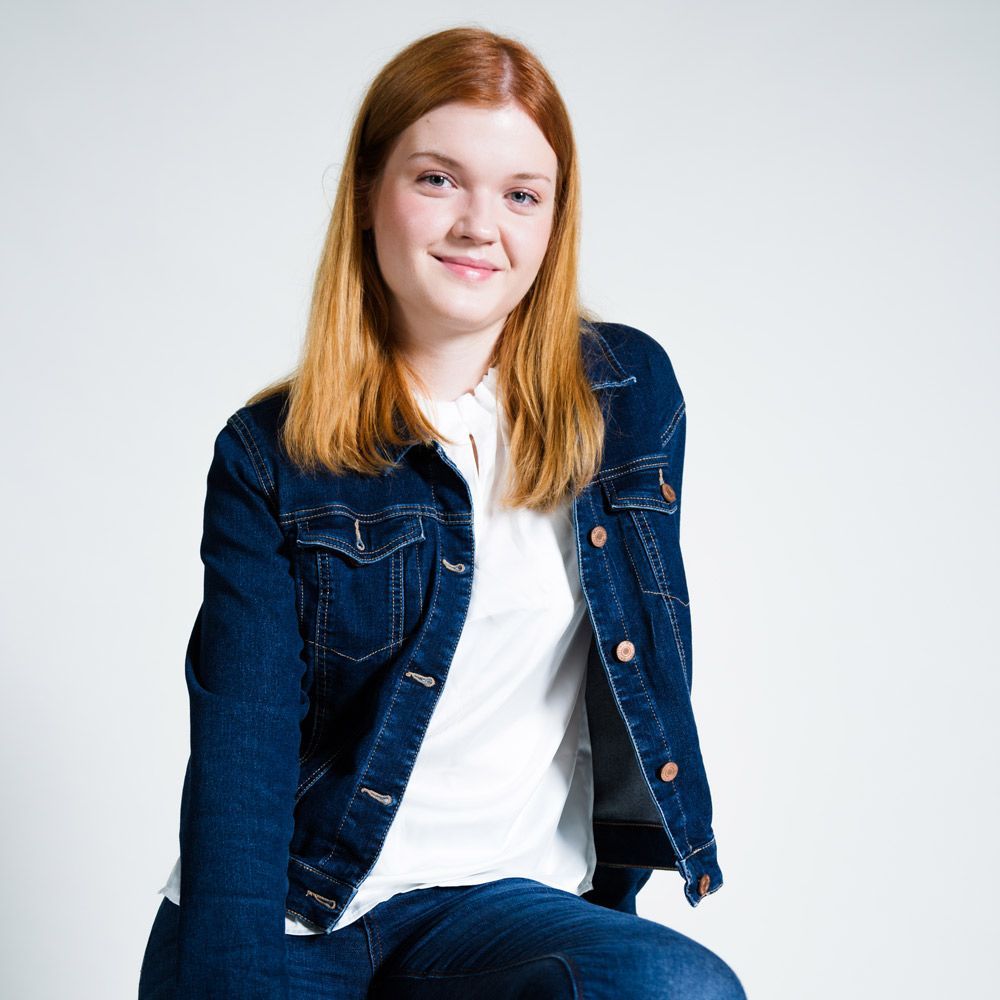 Ein Mann trägt einen weißen Pullover mit einem roten Vogel darauf