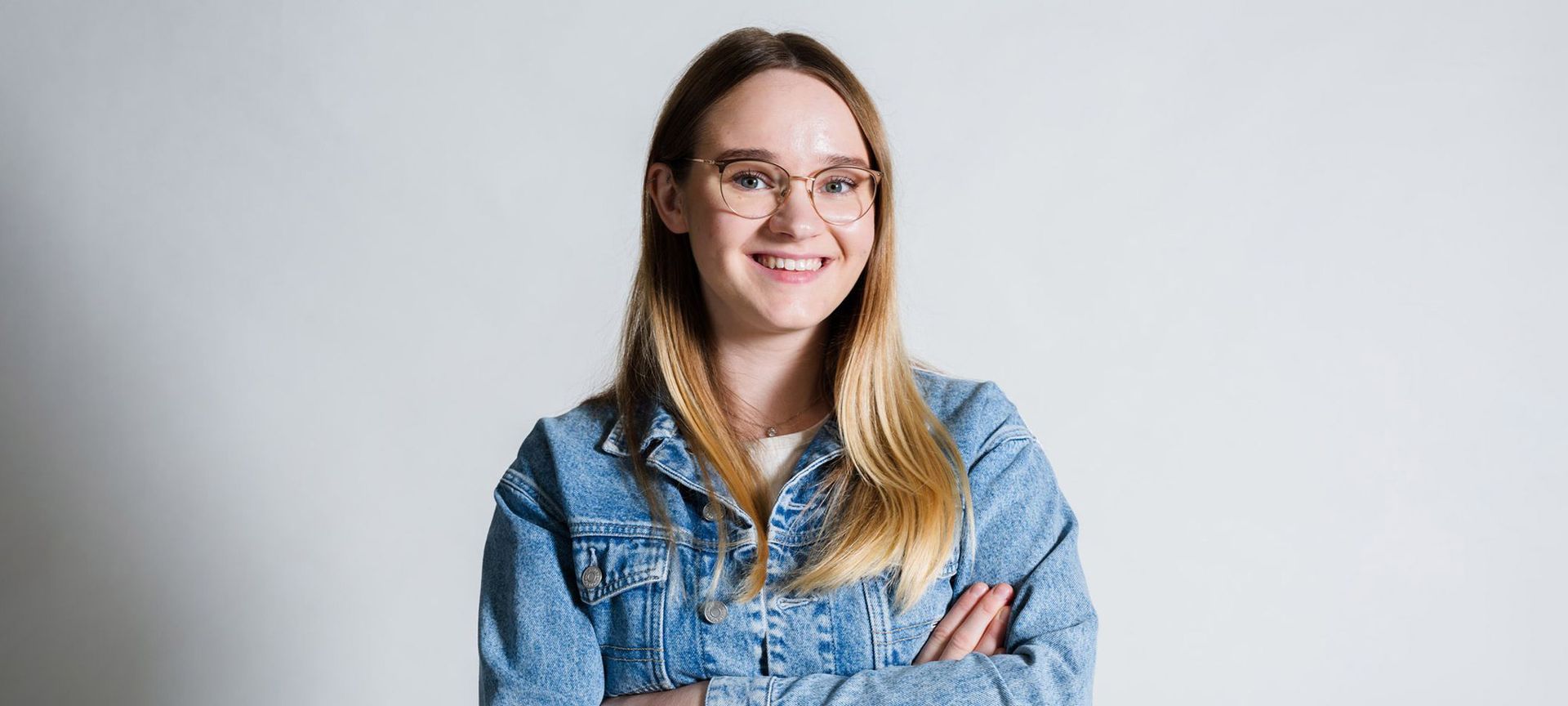 Ein Mann trägt einen weißen Pullover mit einem roten Vogel darauf