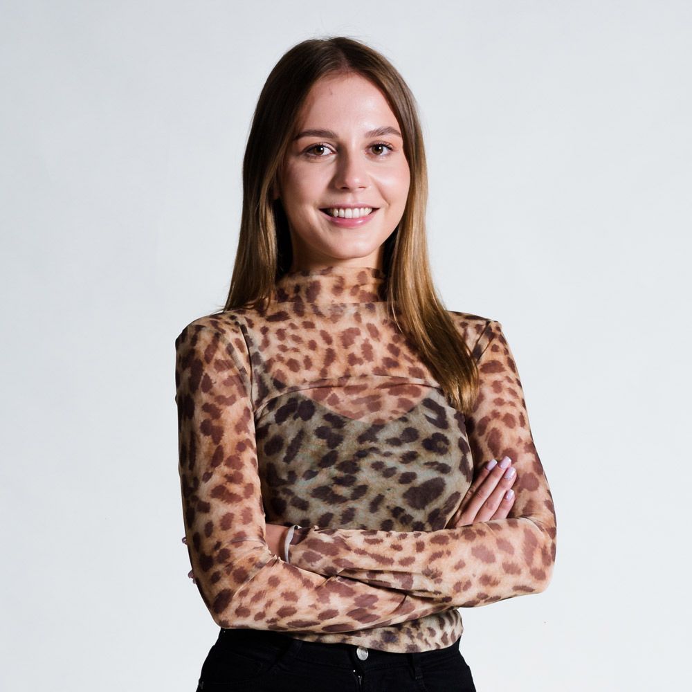 Die Frau trägt eine Brille und lächelt in die Kamera.