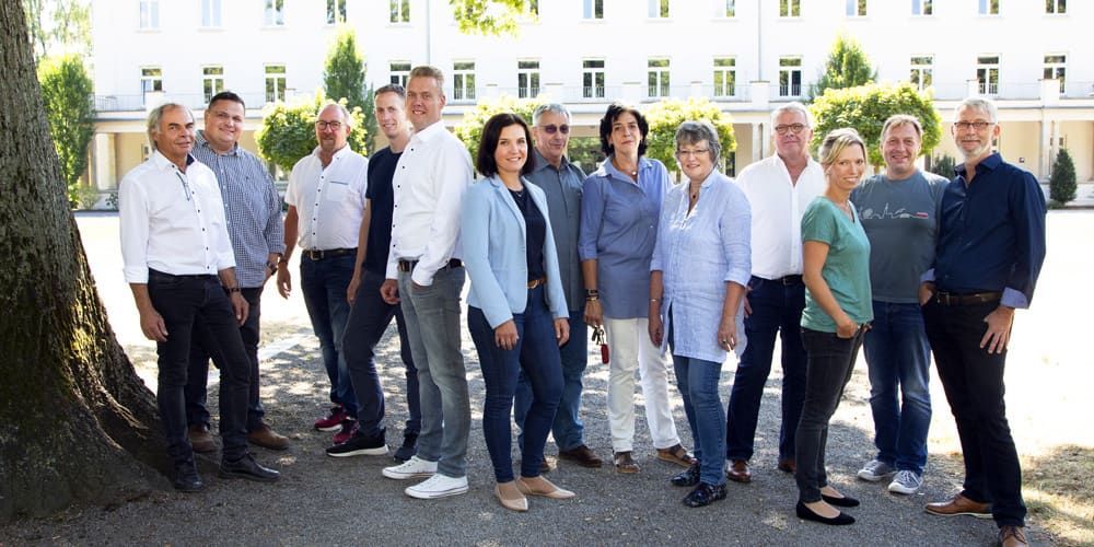 Eine Gruppe von Menschen posiert vor einem Gebäude für ein Foto.