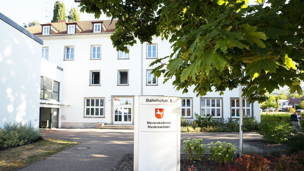 Ein großes weißes Gebäude mit einem Schild davor