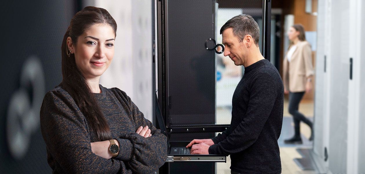 Ein Mann und eine Frau stehen nebeneinander in einem Serverraum.