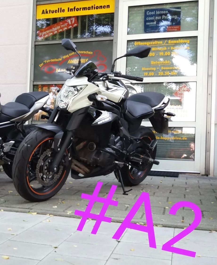 Ein Motorrad ist auf dem Bürgersteig vor einem Schaufenster geparkt, darüber ist der Text 