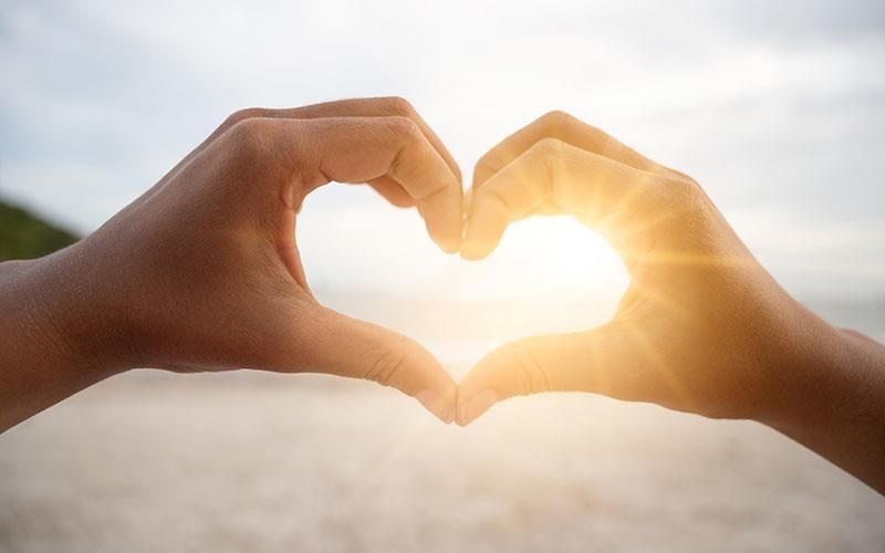 Eine Person formt mit ihren Händen ein Herz.