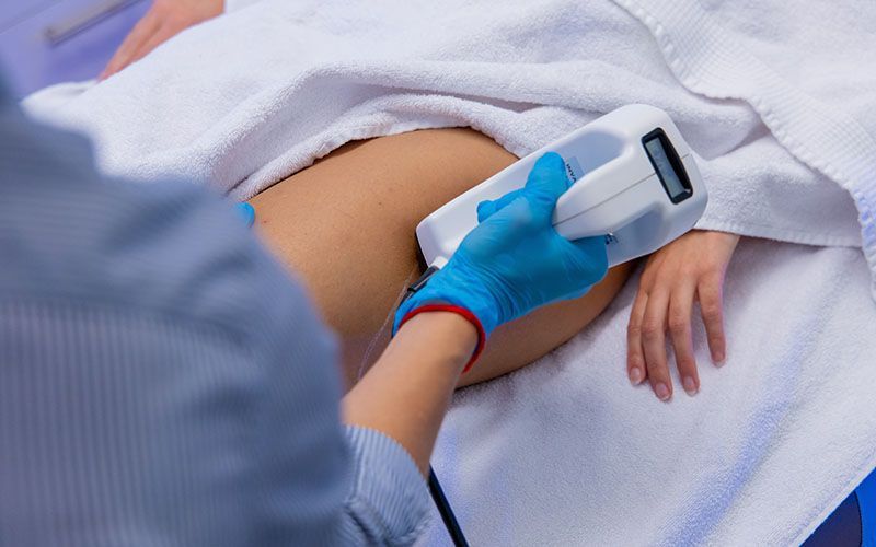 Eine Frau bekommt eine Laserbehandlung am Bauch.