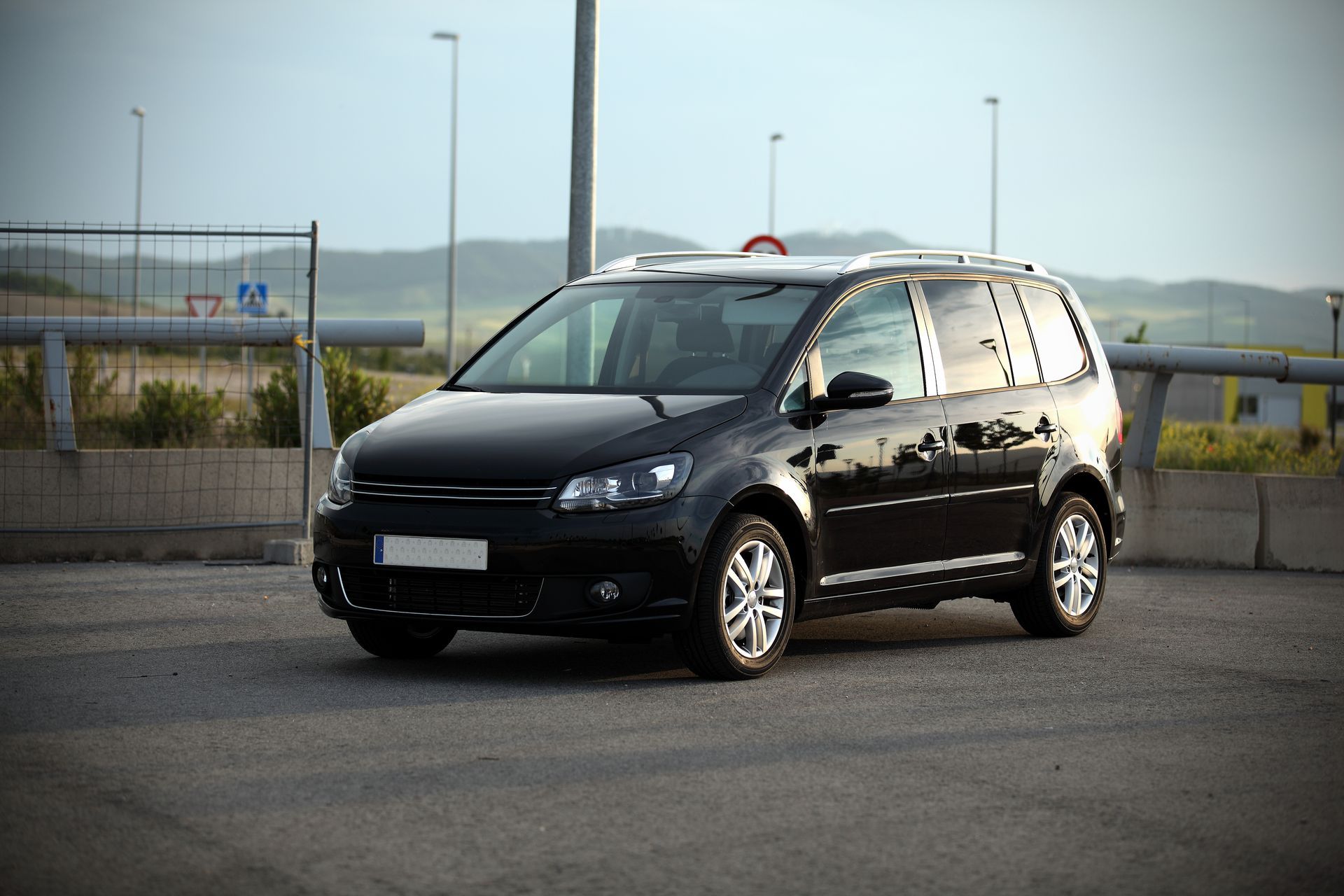Minivan noir stationné sur l'asphalte.