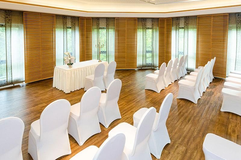 Ein großer Raum mit weißen Stühlen und einem Tisch